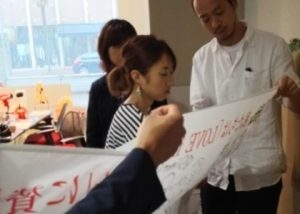 真剣な表情でメッセージを書く上村ともせさん
