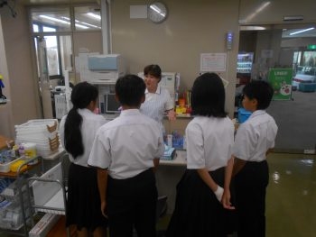 採血室で看護師さんから採血の流れや採血の機械についての説明を受ける生徒さん達